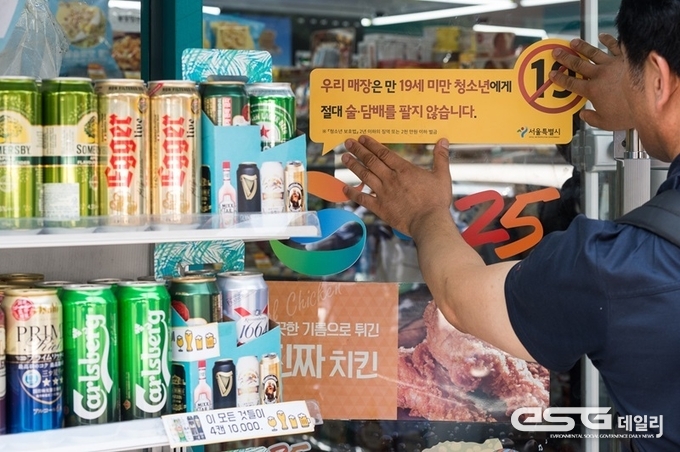서울 종로구 동숭동의 한 편의점에 청소년 대상 술·담배 판매금지 경고문구 스티커를 부착하고 있는 모습.
