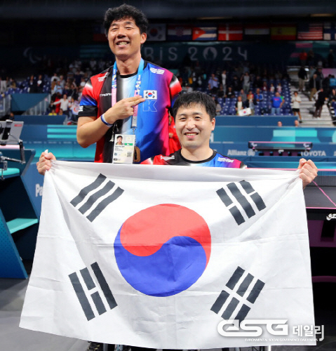 김영건(오른쪽)이 7일(현지시각) 프랑스 파리 아레나4에서 열린 대회 탁구 남자 단식(MS4) 결승전에서 우승한 뒤 태극기를 흔들고 있다. 왼쪽은 김현준 코치.